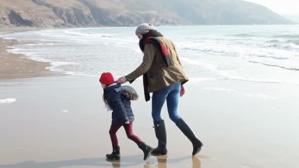 Madre e hija jugando en la playa de invierno — Vídeos de Stock