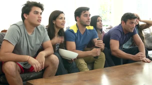 Grupo de amigos sentados no sofá assistindo TV juntos — Vídeo de Stock