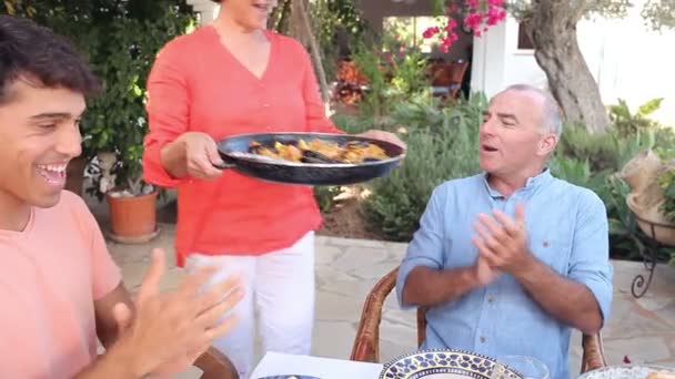 Familia disfrutando de la comida en el jardín — Vídeo de stock