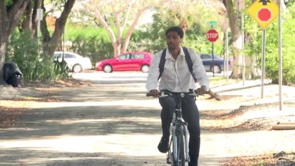 Человек ездит на велосипеде по улице на работу — стоковое видео