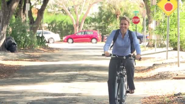 Woman cycling along street to work — Stock Video