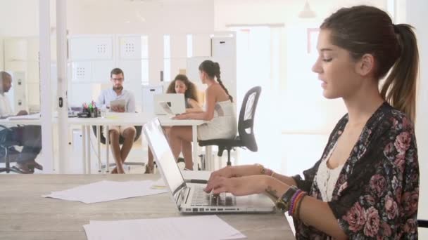 Mujer usando el ordenador portátil y tomando notas — Vídeo de stock