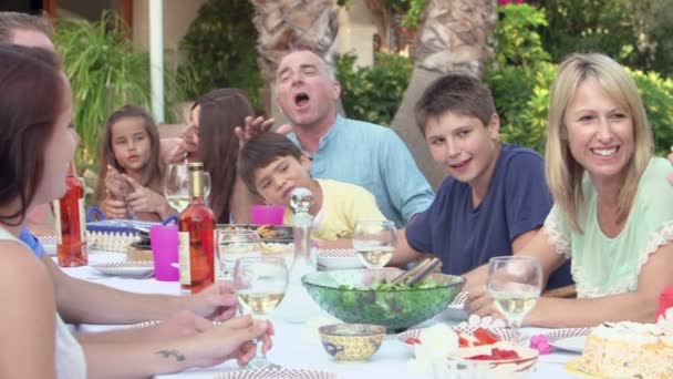 Семья наслаждается едой в саду — стоковое видео