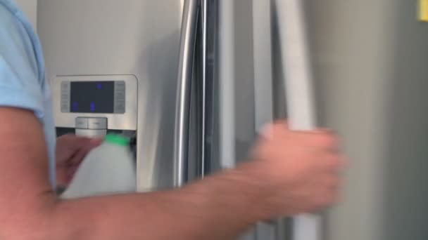 Hombre poniendo cartón de leche en el refrigerador — Vídeos de Stock