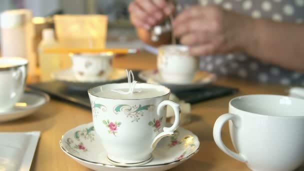 Mujer madura haciendo velas en tazas de té en casa — Vídeo de stock