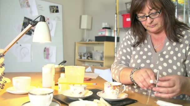Mulher madura fazendo velas em xícaras de chá em casa — Vídeo de Stock