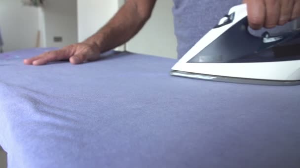 Slow Motion Sequence Of Man Ironing Laundry — Stock Video