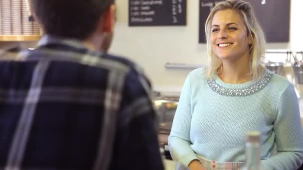 Mujer sirviendo al cliente masculino en la cafetería — Vídeo de stock
