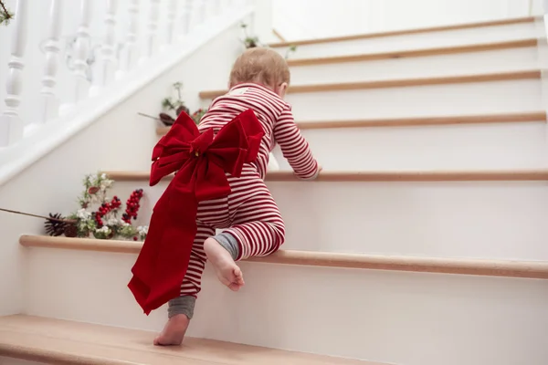 Kleinkind mit Weihnachtsschleife auf Treppe — Stockfoto