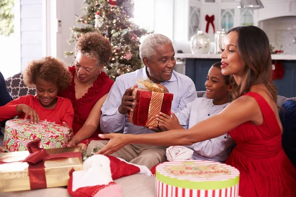 크리스마스 선물을 열어 조부모와 함께 가족 — 스톡 사진