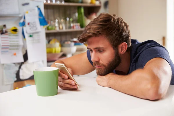 Homem usando telefone celular em casa — Fotografia de Stock