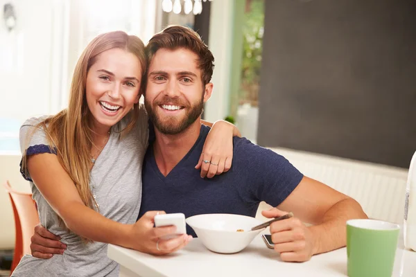 Koppel op ontbijt met behulp van mobiele telefoons — Stockfoto