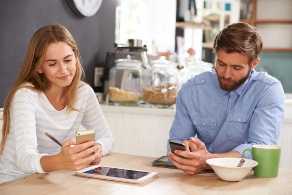 Pareja en el desayuno con teléfonos móviles — Foto de Stock