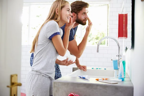 Casal colocando hidratante no banheiro — Fotografia de Stock