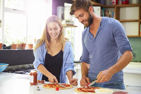 Paar backt Pizza in Küche — Stockfoto