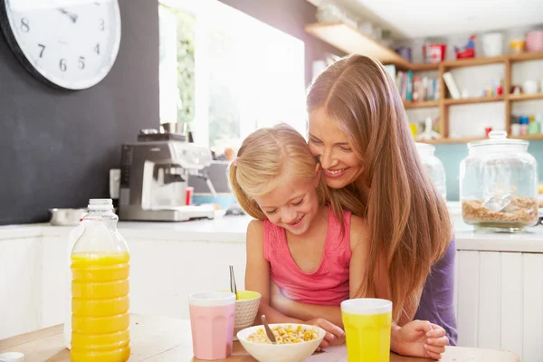 Mãe e filha tomando café da manhã na mesa da cozinha — Fotografia de Stock