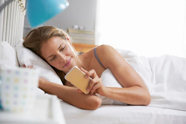 Mujer alcanzando para comprobar el teléfono móvil — Foto de Stock