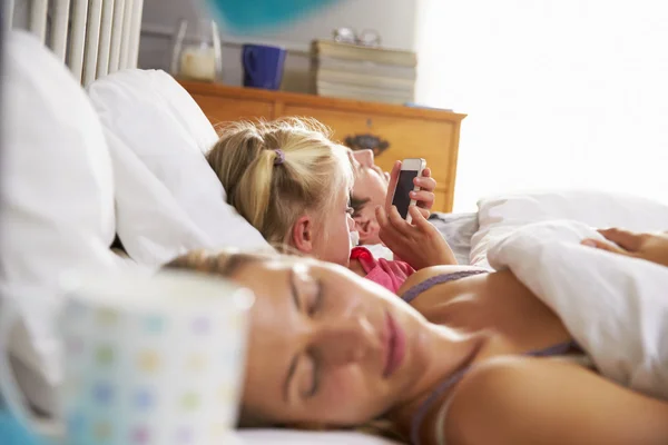 Hija en cama mientras los padres duermen — Foto de Stock