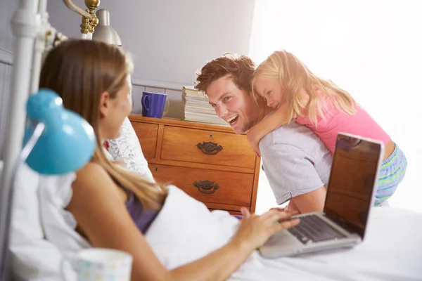 Famille dans la chambre à coucher avec mère en utilisant un ordinateur portable — Photo