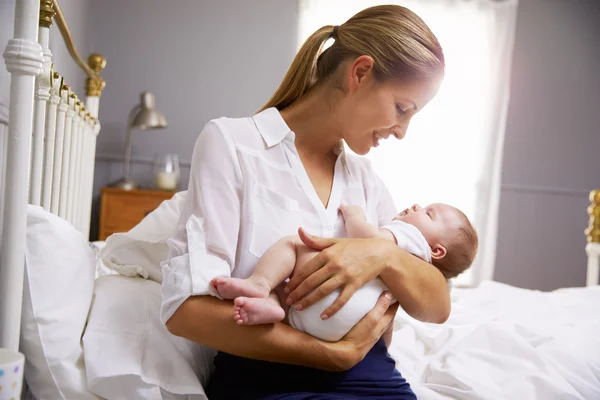 Madre che tiene il bambino in camera da letto — Foto Stock