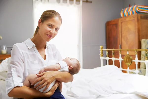Madre sosteniendo bebé en el dormitorio —  Fotos de Stock