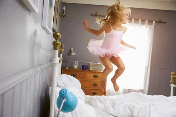 Девушка в костюме балерины прыгает на кровати — стоковое фото