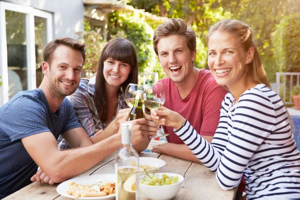 Vänner njuta av drinkar i trädgården — Stockfoto