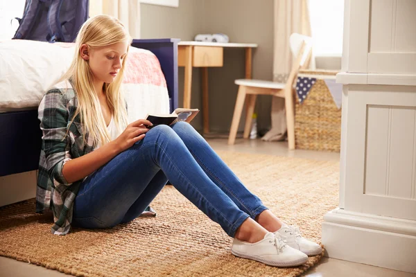 Chica leyendo un libro en su dormitorio — Foto de Stock