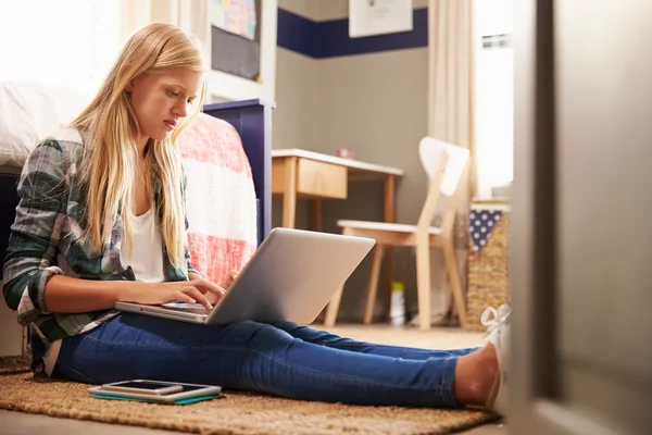 Ragazza utilizzando il computer portatile nella sua camera da letto — Foto Stock