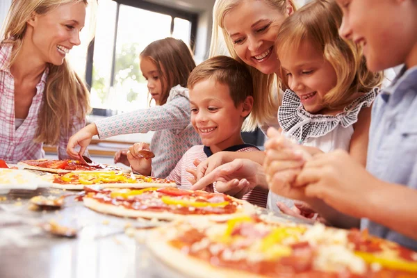 Dvě ženy připravující pizzu s dětmi — Stock fotografie