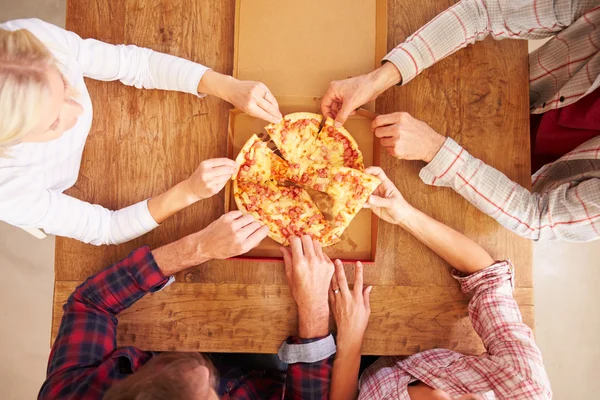 Vrienden delen een pizza samen — Stockfoto
