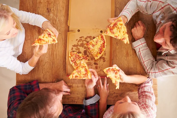 Amigos compartilhando uma pizza juntos — Fotografia de Stock