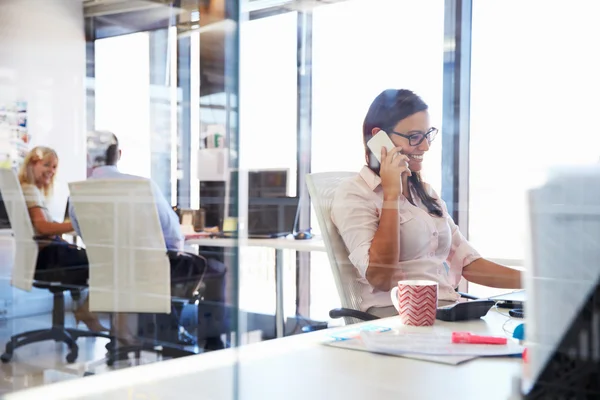 Kobieta mówi, przy użyciu telefonu w biurze — Zdjęcie stockowe