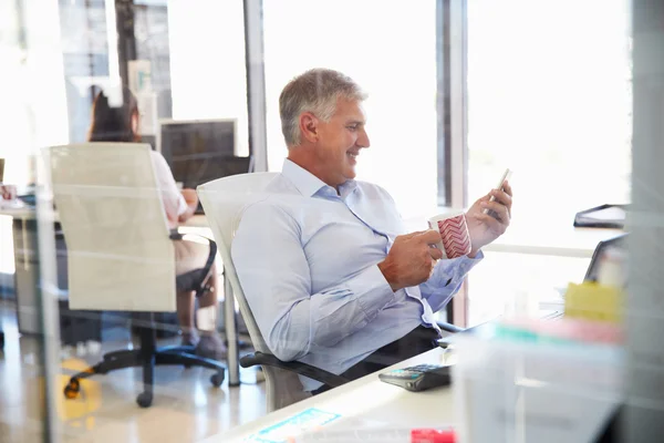 Homem no trabalho usando telefone inteligente — Fotografia de Stock