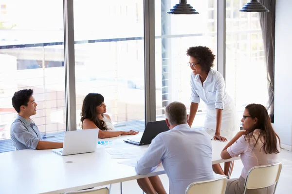 Businesswoman presenting to colleagues at a meeting — Stock Photo, Image