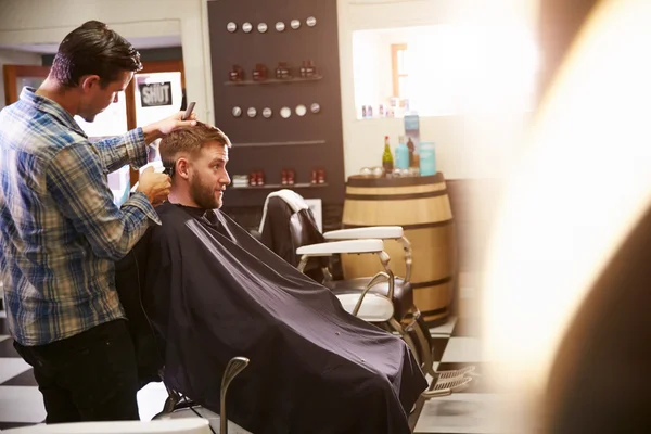 Barbeiro dando corte de cabelo ao cliente — Fotografia de Stock
