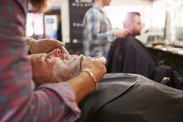 Friseur bereitet Klient auf Rasur vor — Stockfoto