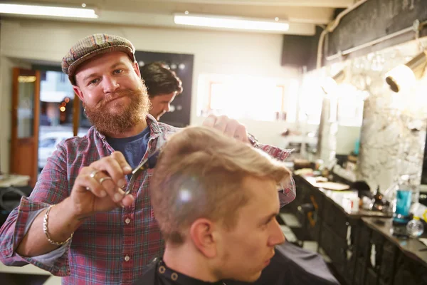 Barbeiro dando corte de cabelo ao cliente — Fotografia de Stock