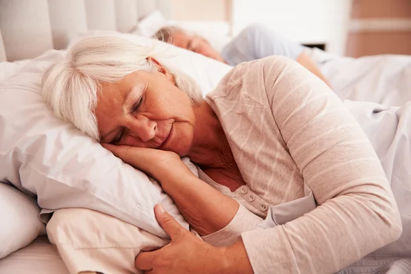 Seniorenpaar liegt im Bett — Stockfoto