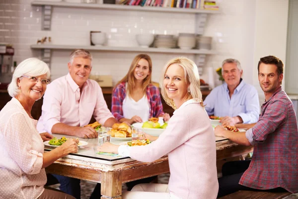 Amigos disfrutando de la comida en casa juntos — Foto de Stock