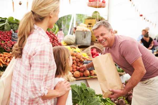 Сім'я купує свіжі овочі на ринку — стокове фото