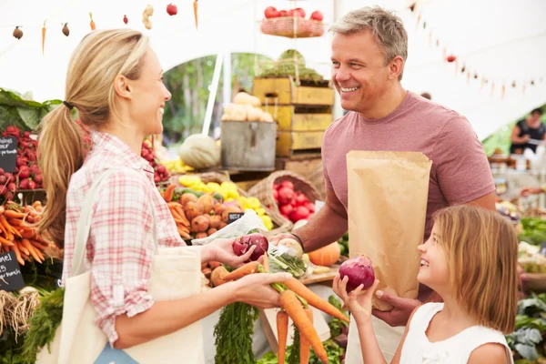 Familjen köper färska grönsaker på marknaden — Stockfoto