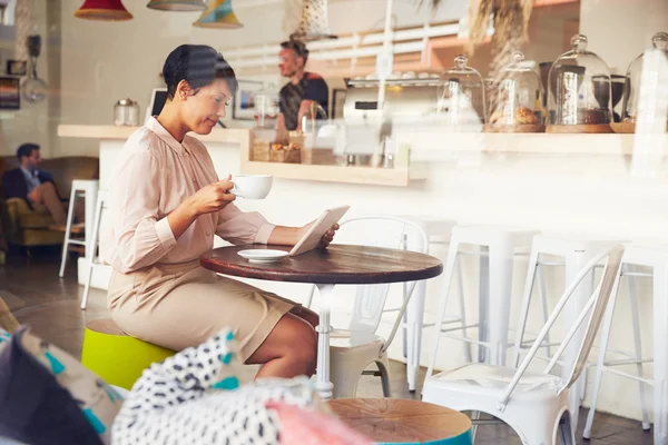 Affärskvinna med hjälp av Tablet PC i ett kafé — Stockfoto