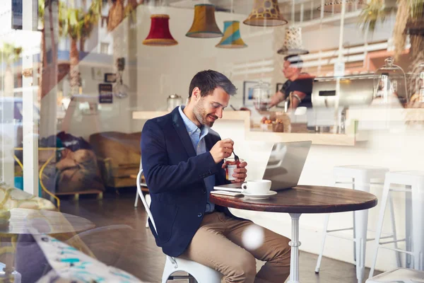 Człowiek siedzi w kawiarni jeść deser — Zdjęcie stockowe