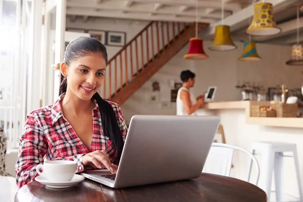 Kobieta korzystająca z laptopa w kawiarni — Zdjęcie stockowe