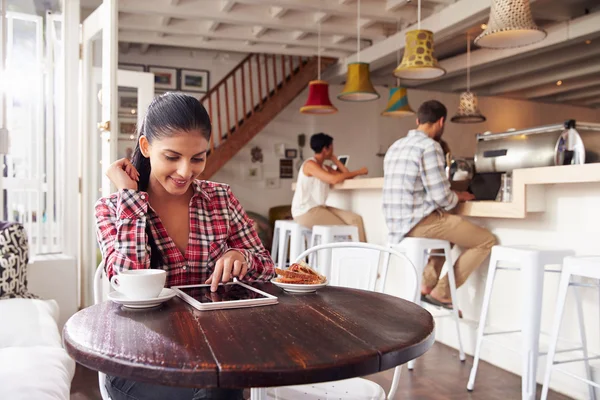 Kvinna som använder laptop i ett café — Stockfoto