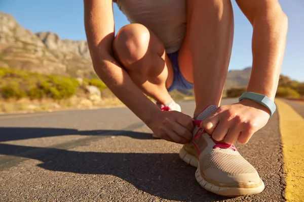 Femmina jogger facendo il suo merletto scarpa — Foto Stock