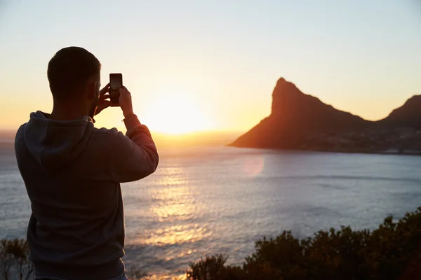 Homme prenant une photo du soleil — Photo