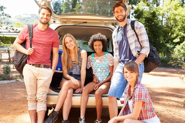 Amigos en viaje sentado en tronco de coche — Foto de Stock