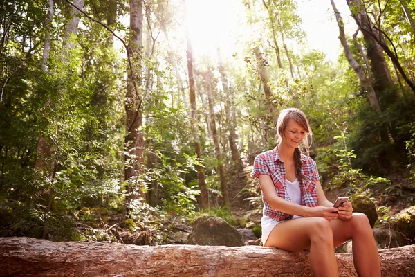 Mujer usando teléfono móvil en el bosque —  Fotos de Stock